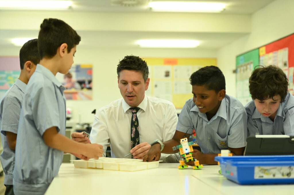 Teacher with students learning about robotics