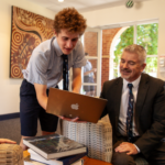 Student working with a teacher on a laptop