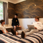 Boys laying on a bed working